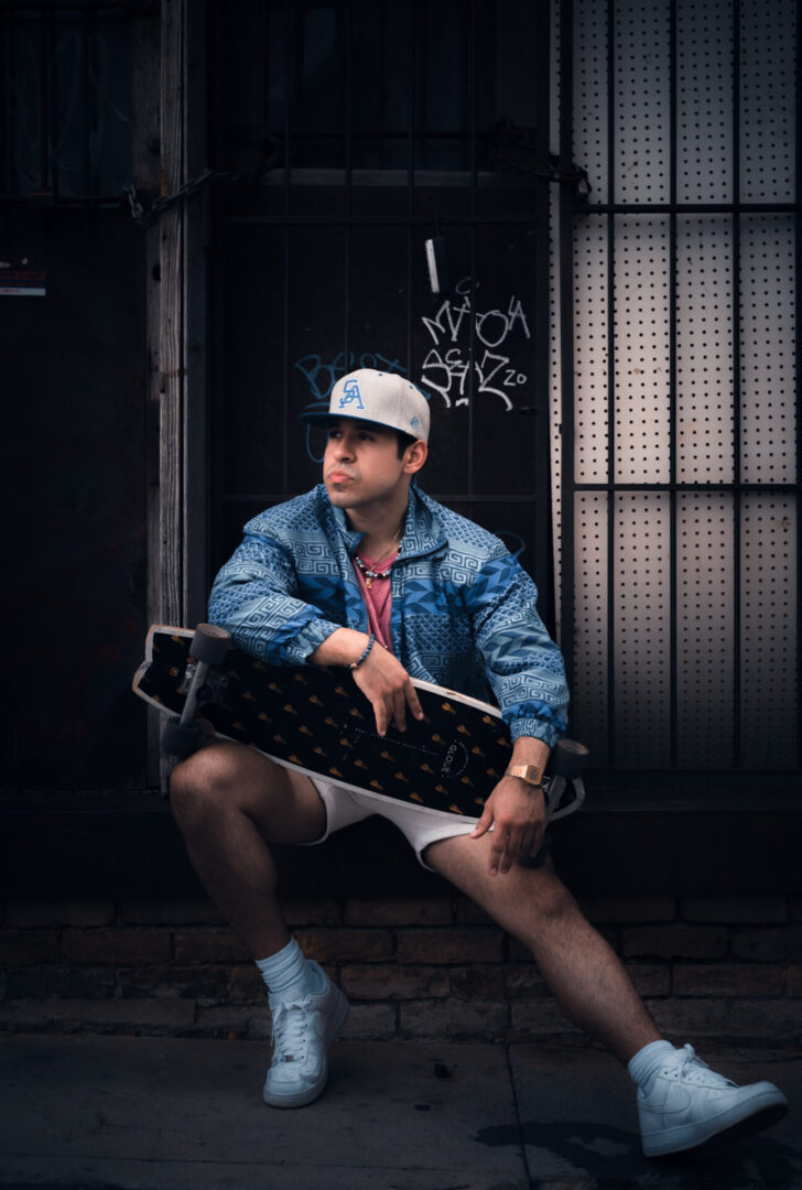 A man wearing a cap while holding a skateboard